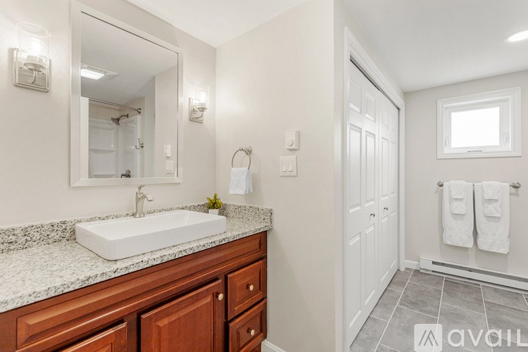 A bathroom with a sink, mirror, and towel rack.