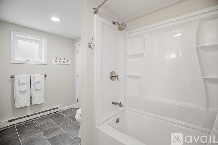 A white bathroom with a tub, toilet, and sink.