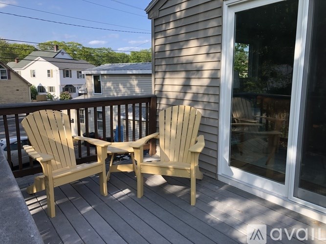 Two chairs and a table on a deck.