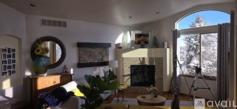 A living room with a fireplace and a painting on the wall.