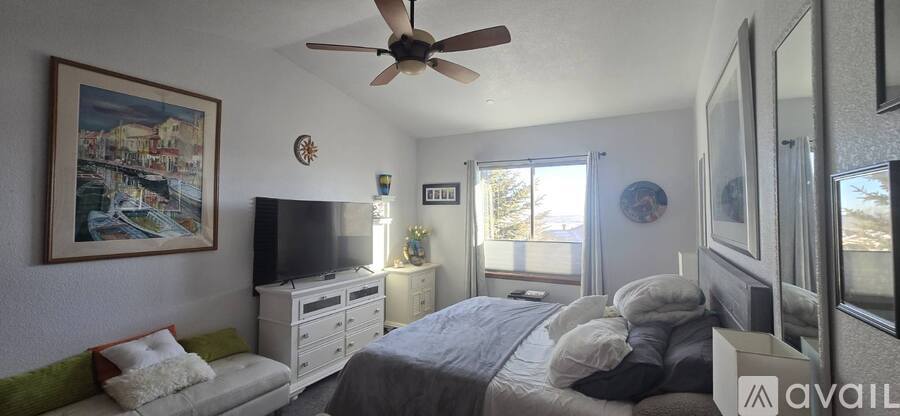 A bedroom with a bed, dresser, and a painting on the wall.