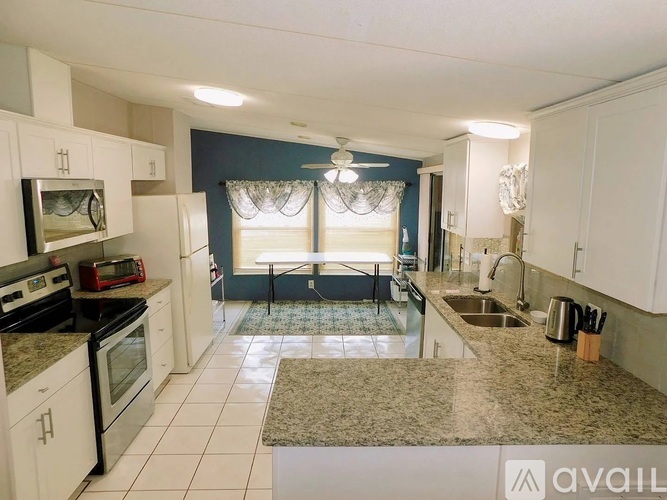 A kitchen with white cabinets and a granite countertop.