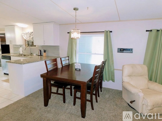 A dining room with a table and chairs.