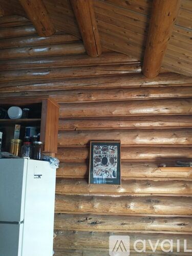 A small framed picture hangs on a wooden wall.