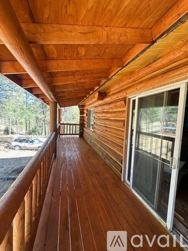 A wooden deck with a railing and a window.