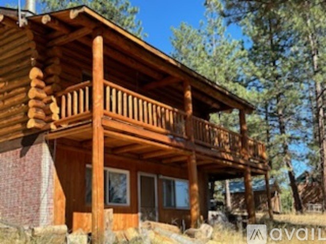 A wooden cabin with a balcony and a window.