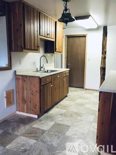 A kitchen with wooden cabinets and a checkered floor.