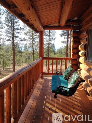 A wooden balcony with a chair and a table.