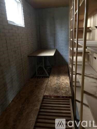 A room with a brick wall and a table with a bench in front of it.