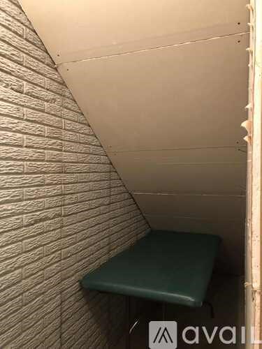A small room with a bench and a brick wall.