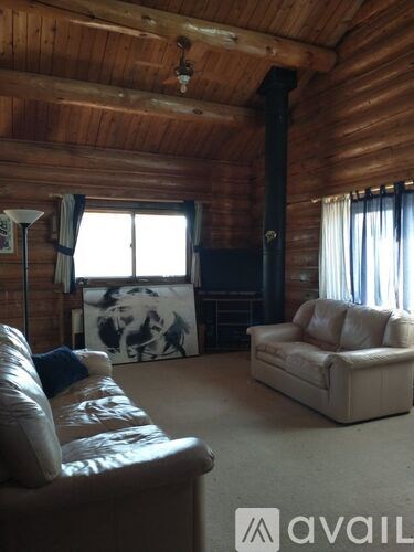 A living room with a couch, a chair, and a television.