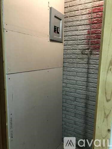 A white door with a silver handle and a silver plate on the wall.