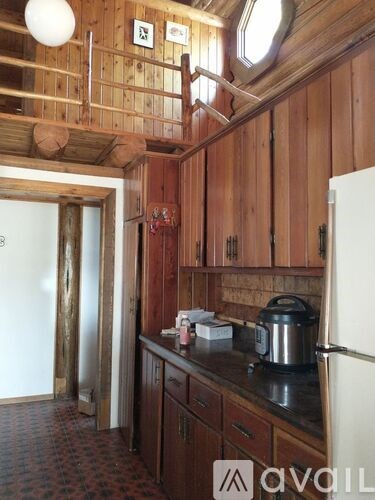 A kitchen with wooden cabinets and a white fridge.