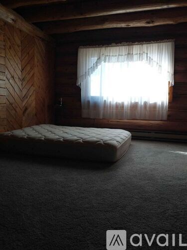 A bedroom with a bed and a window with curtains.