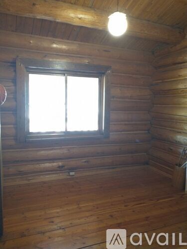 A wooden room with a window and a light on the ceiling.