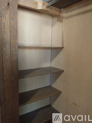 A wooden shelf with four shelves is mounted on a wall.
