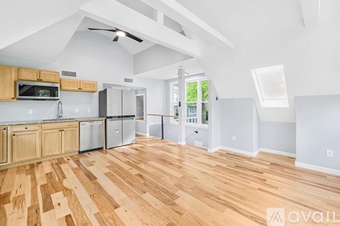 A kitchen with wooden floors and a refrigerator.