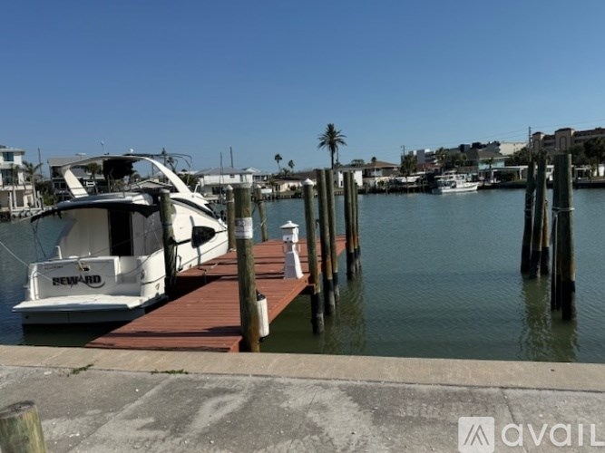 A white boat is docked at a pier.