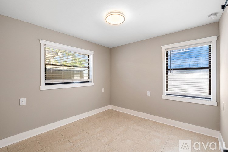A room with a tiled floor and two windows.