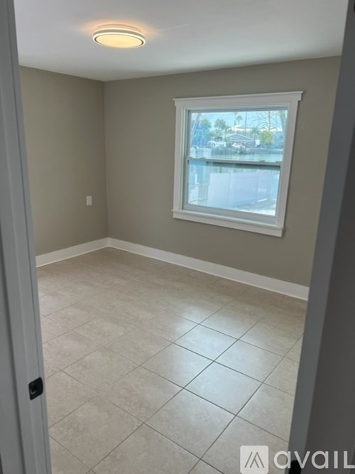 A room with a window and tiled floor.
