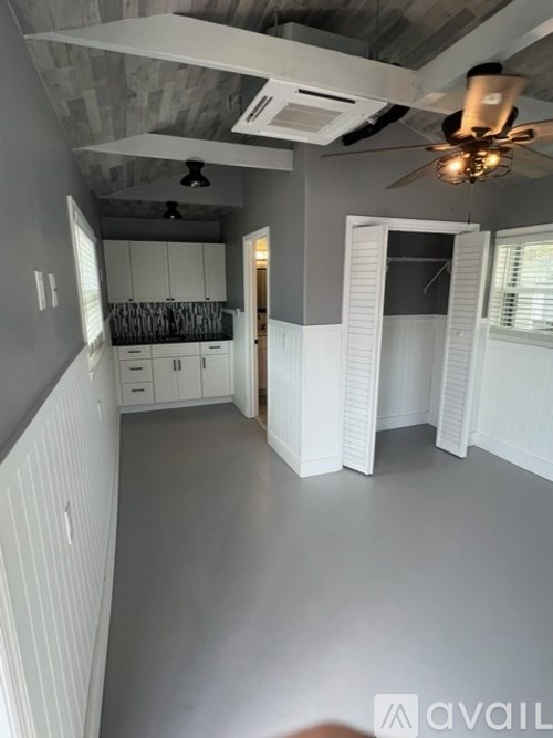 A room with a ceiling fan and a cabinetry.