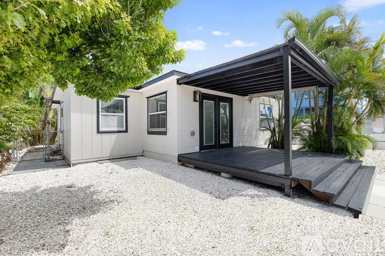 A small house with a porch and a covered patio.
