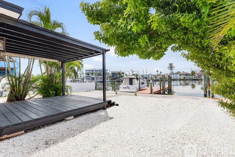 A patio with a wooden deck and a gravel area under a roof.
