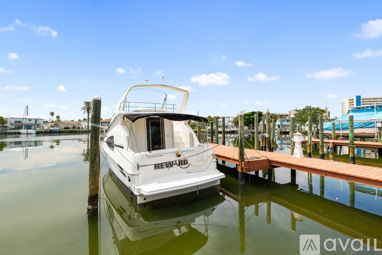 A white boat with the word "HEWARD" on it is docked at a pier.