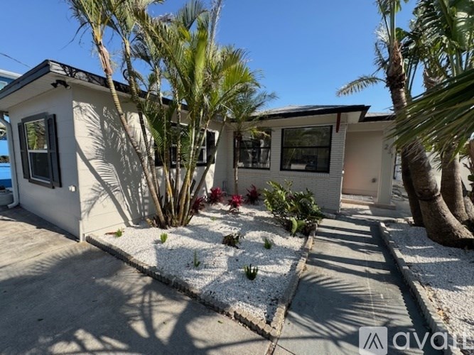 A white house with a garden in front.