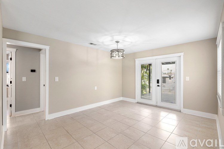 A small house with a red roof and a blue tarp covering a part of it.