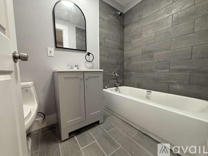A bathroom with a tub, toilet, and sink.