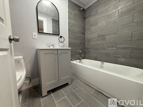 A bathroom with a tub, toilet, and sink.