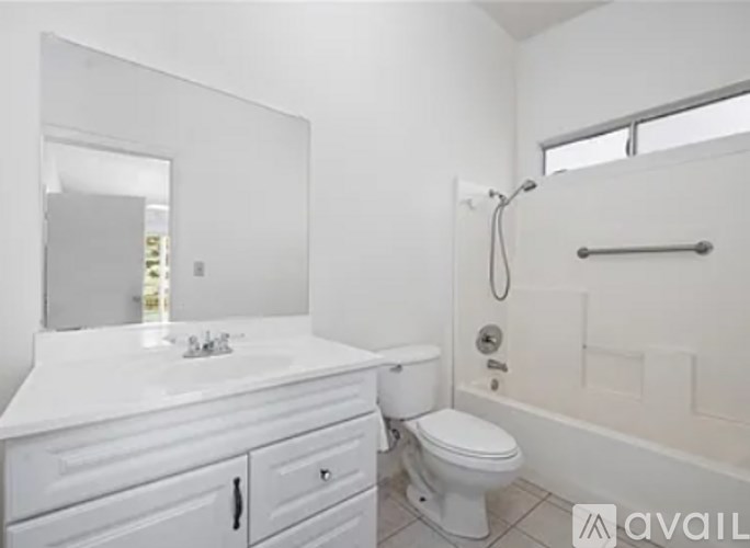 A white bathroom with a toilet, sink, and bathtub.