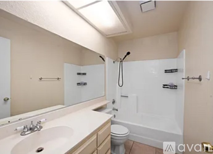 A bathroom with a white tub, sink, and toilet.