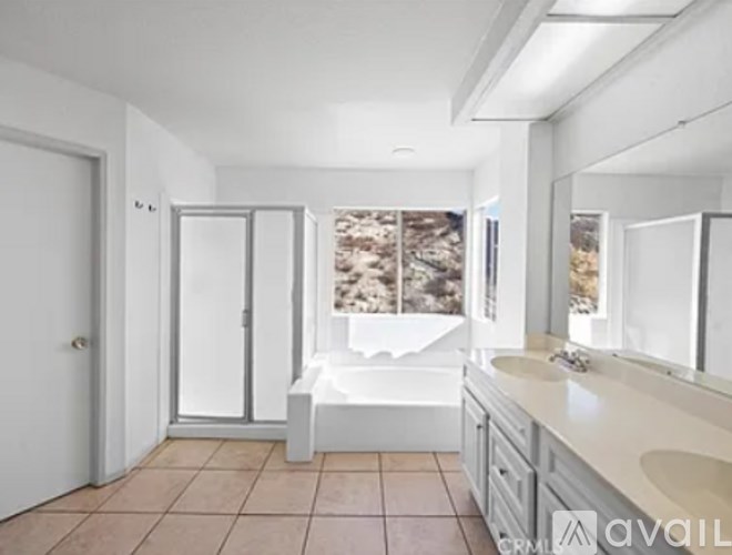 A bathroom with a tub, sink, and mirror.