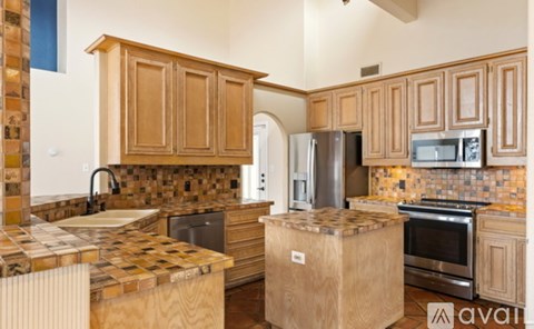 A kitchen with wooden cabinets and a tiled backsplash.