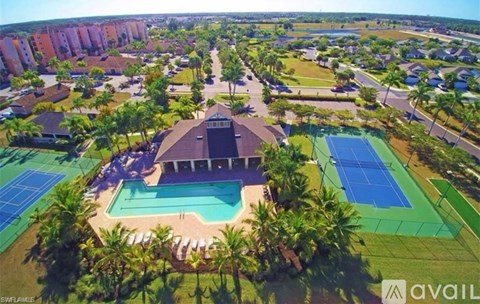 A bird's eye view of a resort with a swimming pool and tennis courts.