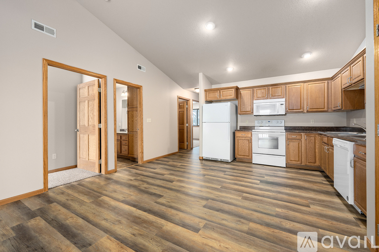 A kitchen with wooden floors and white appliances.