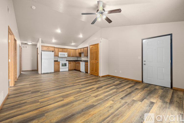 A spacious room with wooden flooring and a ceiling fan.