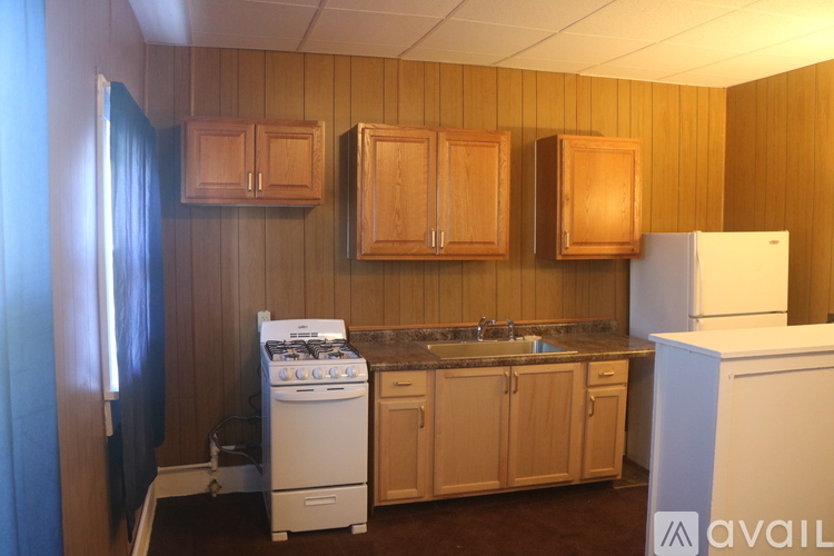 A kitchen with wooden cabinets and a white refrigerator.