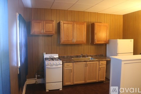 A kitchen with wooden cabinets and a white refrigerator.