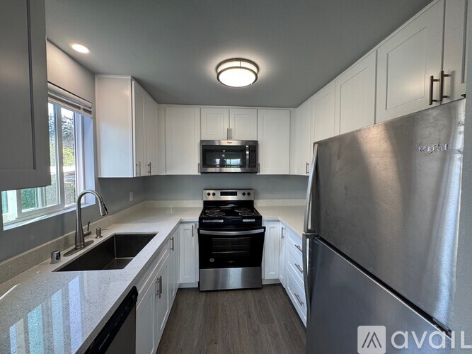 A modern kitchen with stainless steel appliances and white cabinets.