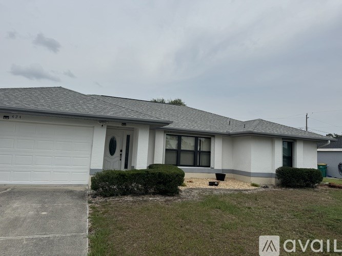 A house with a grey roof and a white garage door.