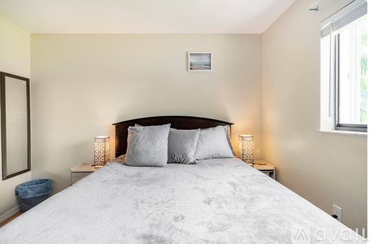 A bedroom with a large bed and a window.