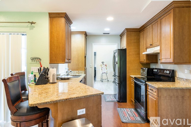 A kitchen with wooden cabinets and a granite countertop.