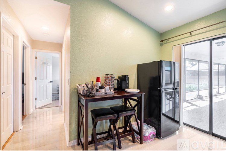 A kitchen area with a table and chairs and a refrigerator.
