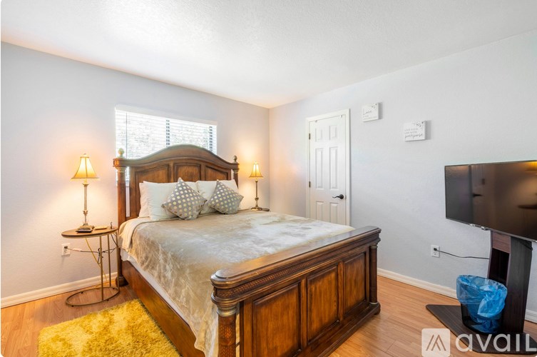 A bedroom with a large bed and a flat screen TV.