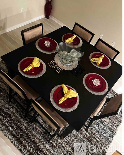 A black table with red and gold plates and napkins is set for a meal.