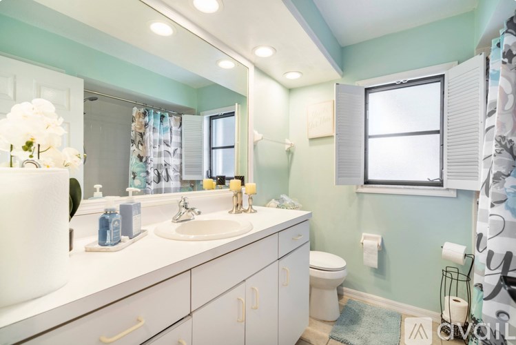 A bathroom with a white sink and a white toilet.
