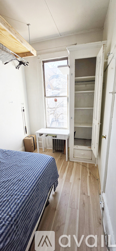 A bedroom with a bed, nightstand, and pictures on the wall.